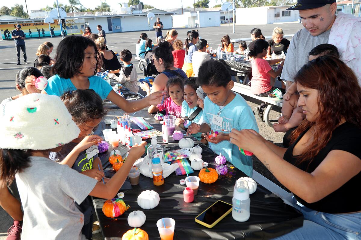 Students and parents participate in a pumpkin decorating activity during Think Together's "Lights On Afterschool" event. 