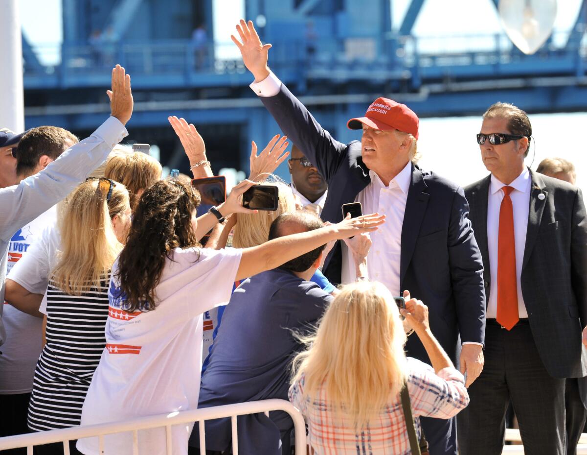 El precandidato presidencial republicano Donald Trump saluda a sus simpatizantes mientras camina al escenario de un acto proselitista en Jacksonville, Florida.