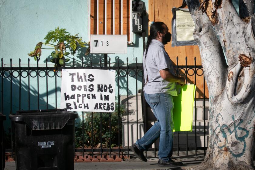 LOS ANGELES, CA - SEPTEMBER 16: Community members put signs before a news conference in front of their homes to protest the city's handling of the June 30 LAPD fireworks explosion that damaged local homes. on Thursday, Sept. 16, 2021 in Los Angeles, CA.(Jason Armond / Los Angeles Times)