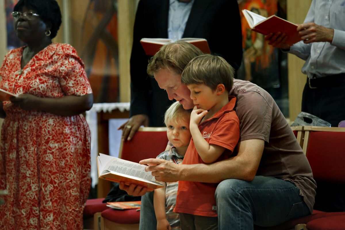 Tom Catchpole, age 34, and his two children Rufferty, age 2, and Percy, age 4, right, attend St. Matthew's Brixton Church in Braxton on Sunday, June 26, 2016.