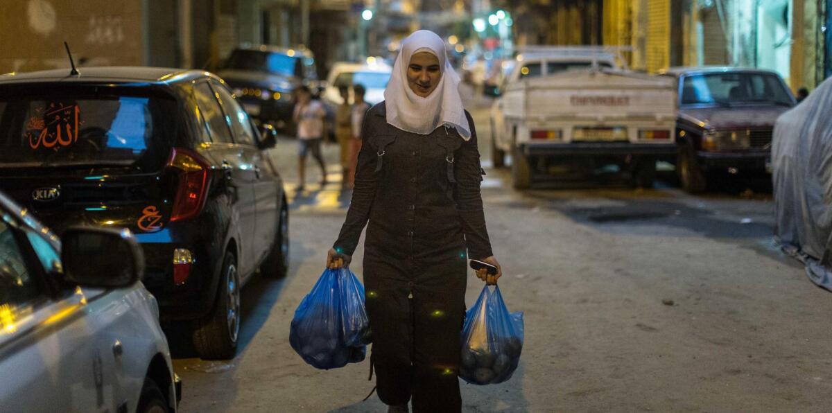 Yasmine, Kamar's 16-year-old daughter, brings vegetables to the catering business.