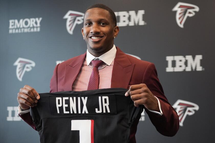 Atlanta Falcons first round draft choice quarterback Michael Penix Jr., holds a Falcons jersey during a news conference Friday, April 26, 2024, in Flowery Branch, Ga. (AP Photo/John Bazemore)