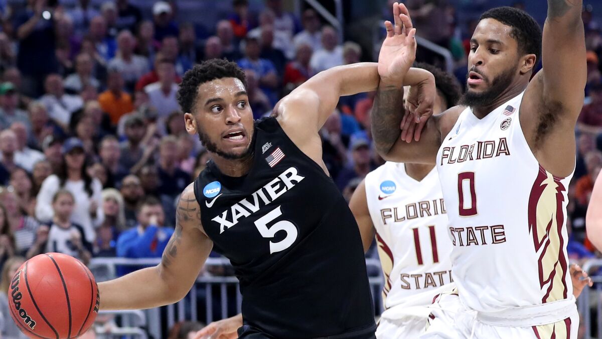 Xavier guard Trevon Bluiett looks to pass as his drive is cut off by Florida State forward Phil Cofer during the second half Saturday.