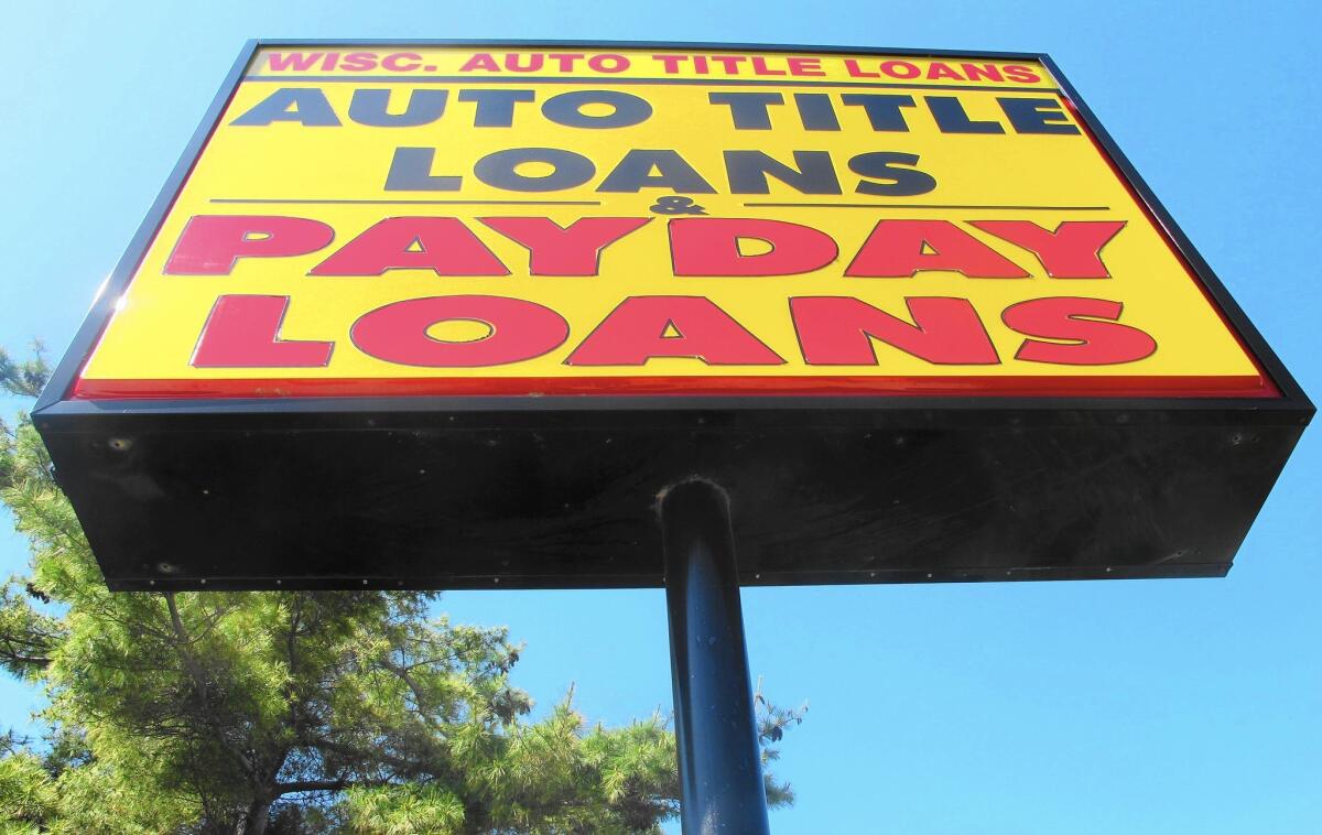 Payday lenders make about $38.5 billion in loans a year. Above, a sign for Wisconsin Auto Title Loans in Madison, Wis.