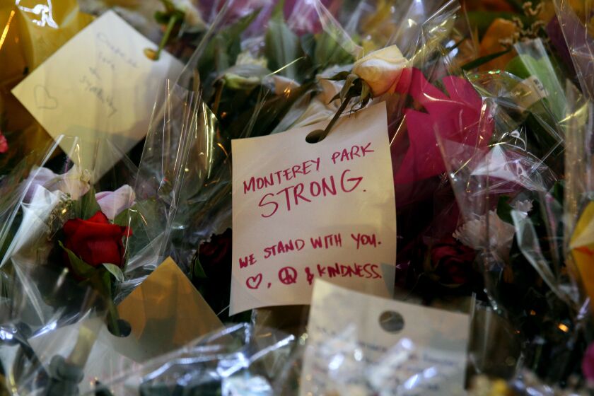 A note attached to flowers left for the 11 shooting victims, at the memorial site in front of Star Ballroom Dance Studio in Monterey Park on Thursday, Jan. 26, 2023.