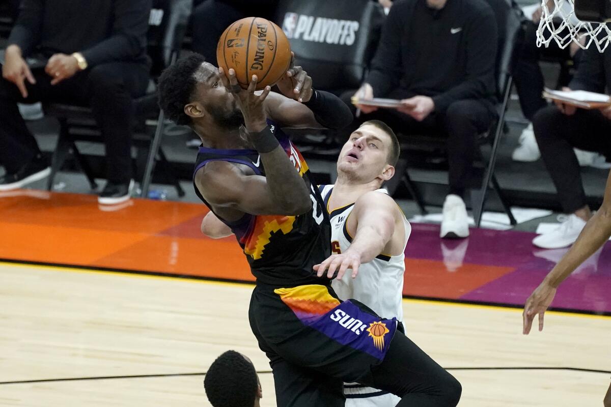 Phoenix Suns center Deandre Ayton is fouled by Denver Nuggets center Nikola Jokic, right, during the second half of Game 1 of an NBA basketball second-round playoff series, Monday, June 7, 2021, in Phoenix. (AP Photo/Matt York)