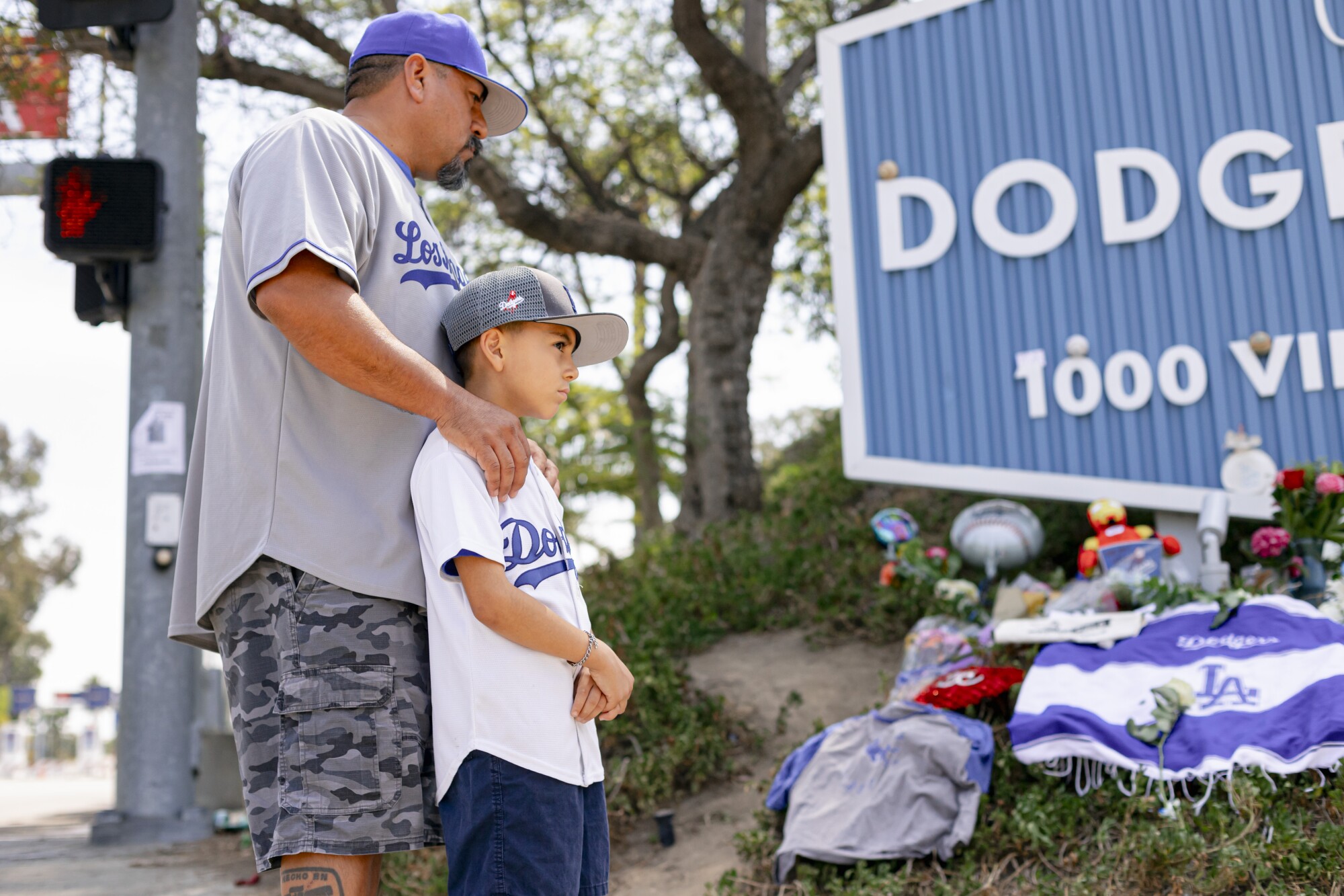Rudy Escobar and Rudolfo Escobar look at the growing memorial for longtime beloved Dodgers announcer, Vin Scully.