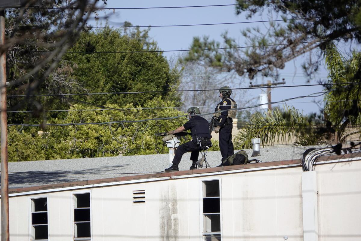 Two police officers on a rooftop.