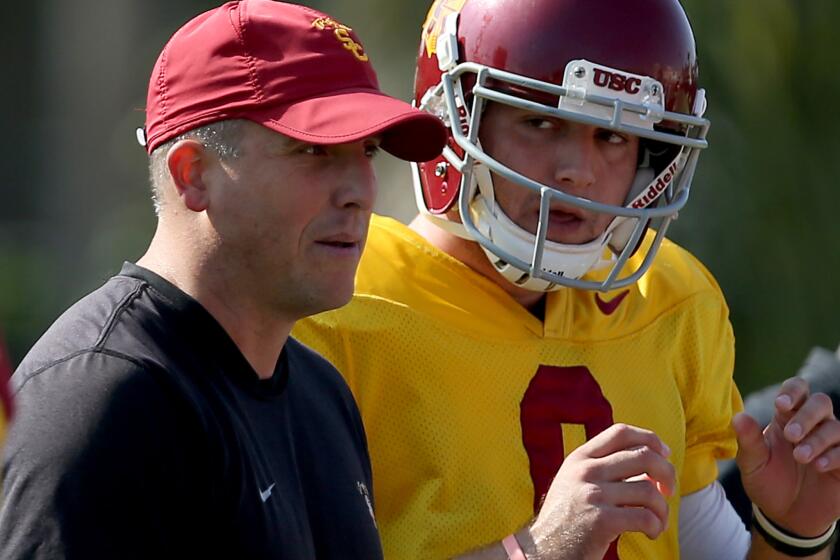Clay Helton works with Trojans quarterback Cody Kessler during a practice on Oct. 2, 2013.