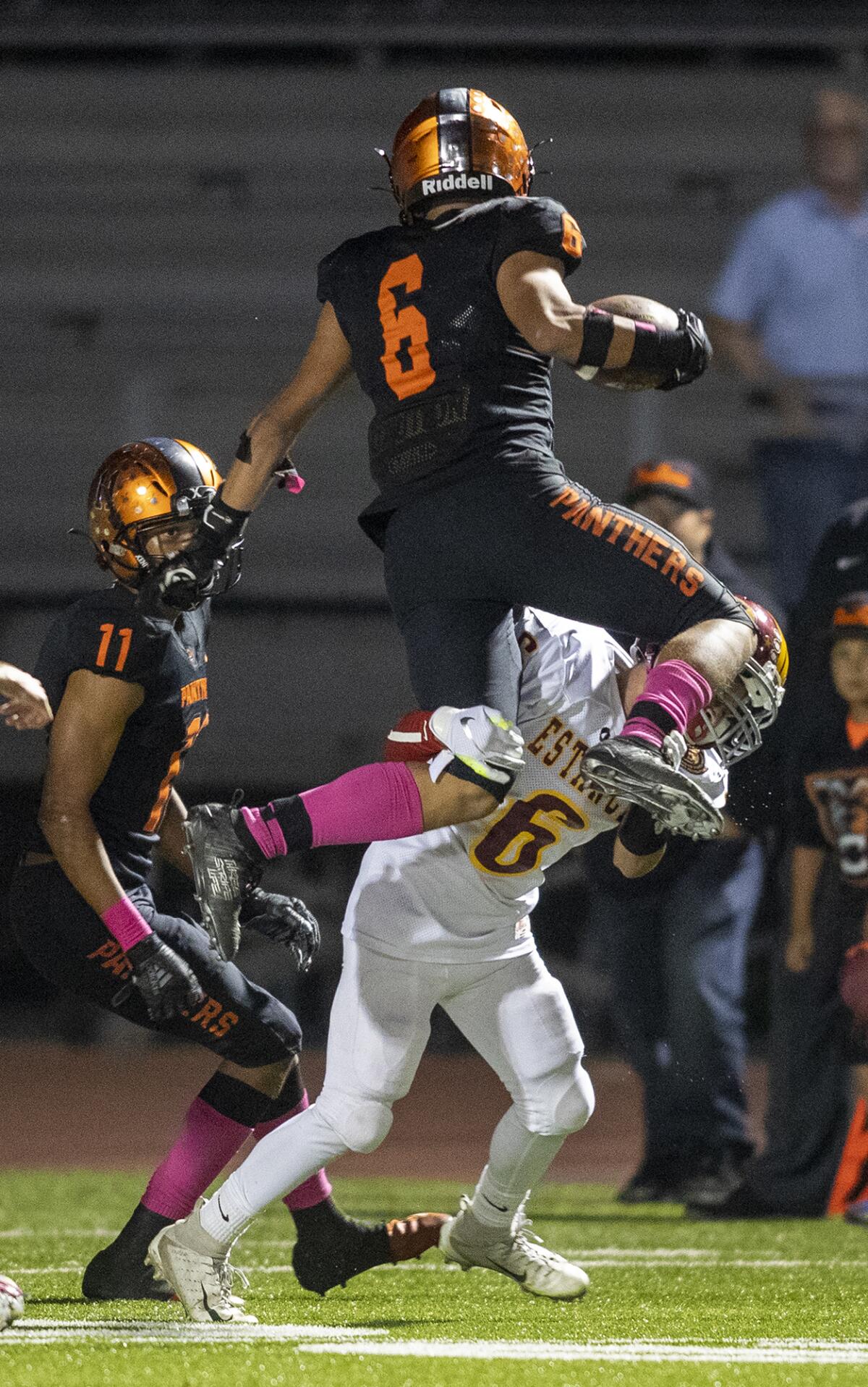 Orange's Isacc Galvan attempts to leap over Estancia defender Yovani Avila in an Orange Coast League game on Thursday at Segerstrom High in Santa Ana.