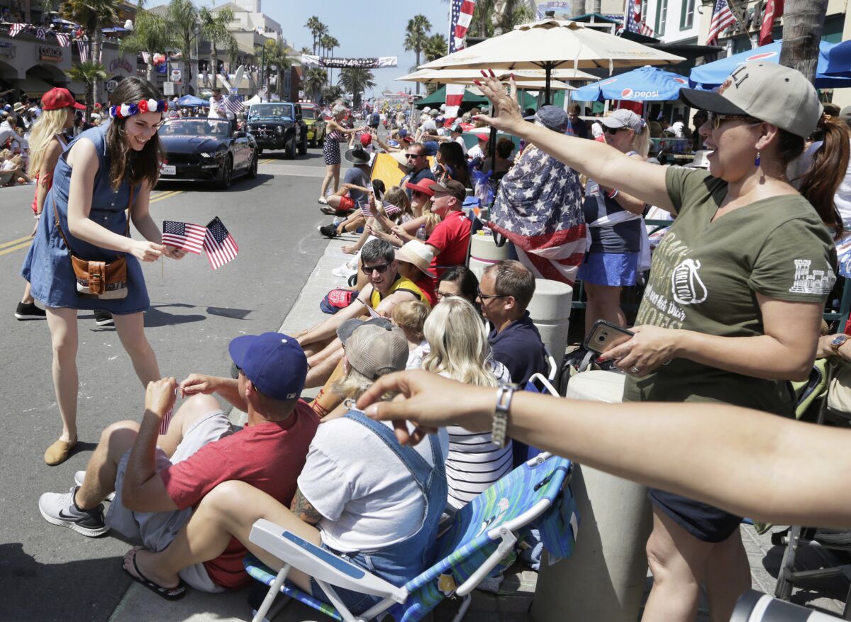 Brana Vlasic hands out American flags for Surf City’s Fourth of July Parade in 2019.