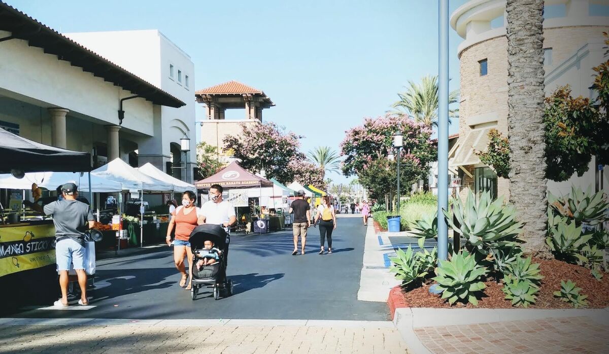 A few customers stroll the Otay Ranch Farmers Market on a Tuesday summer evening at Otay Ranch Town Center.