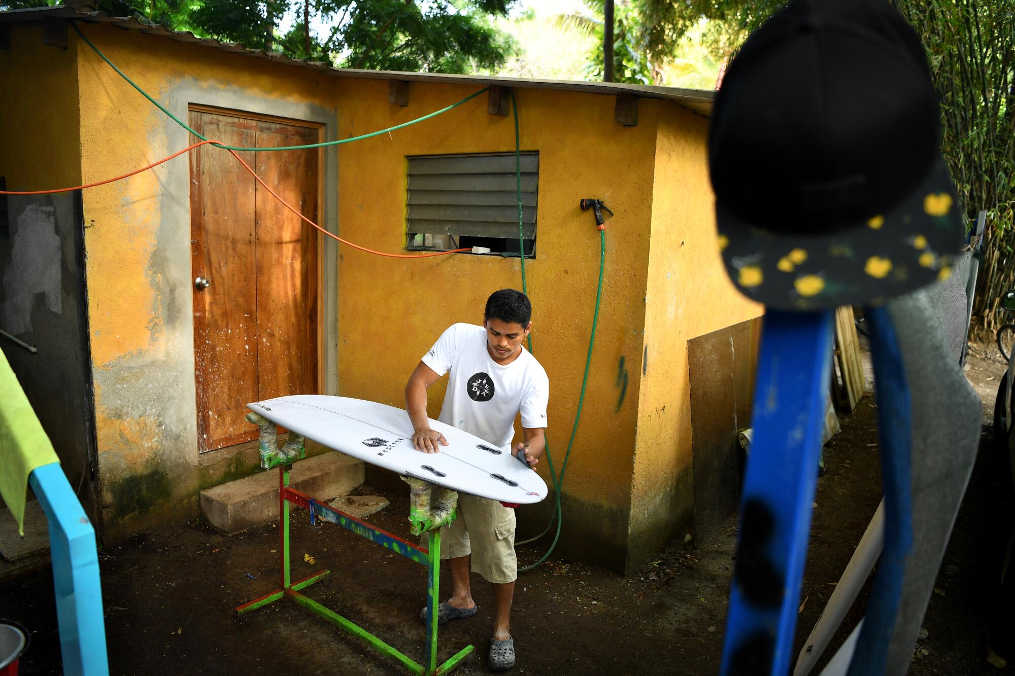 Local Alex Hernandez fixes a surfboard at Surf City.