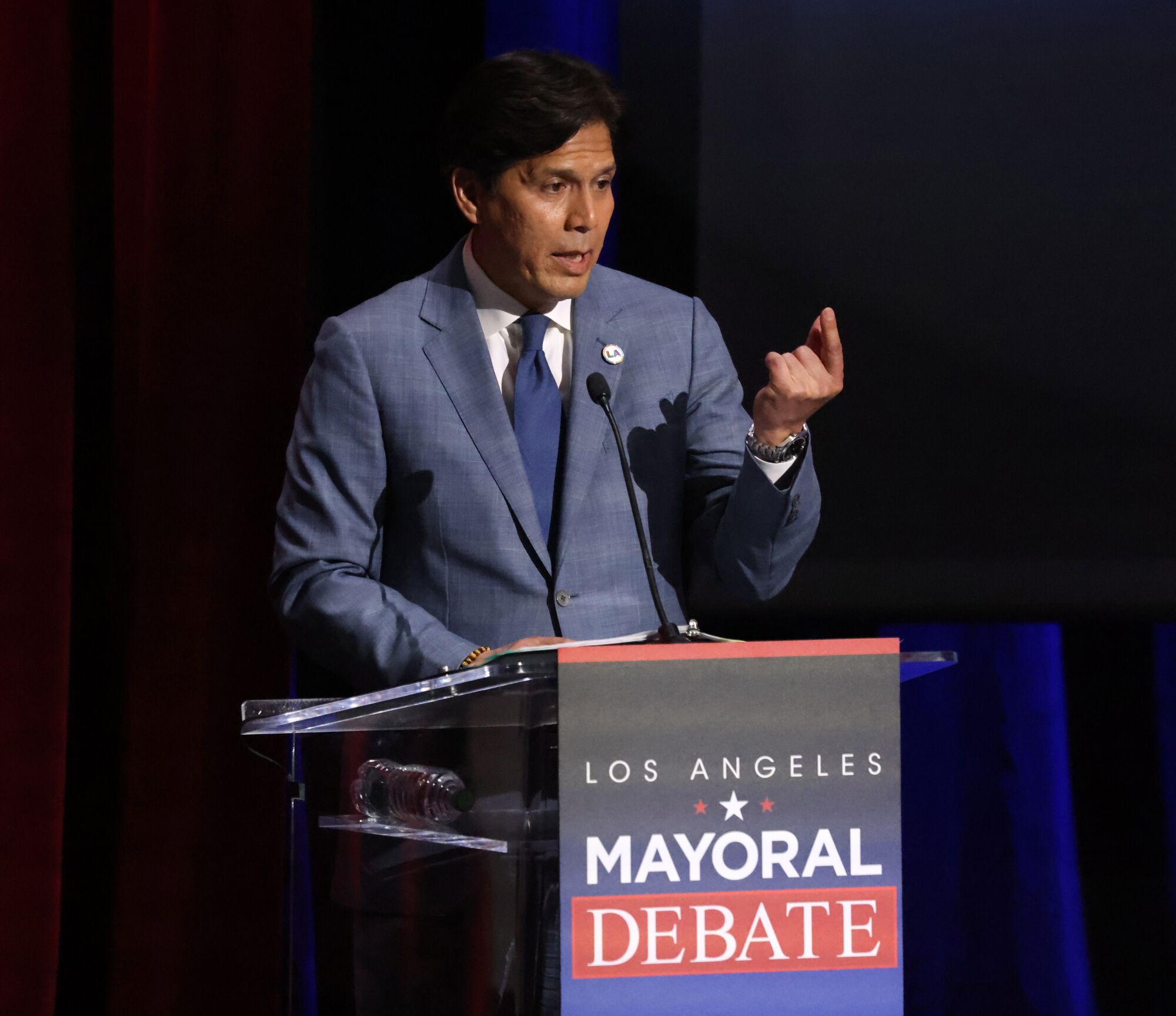 Kevin de Leon gestures from a lectern 