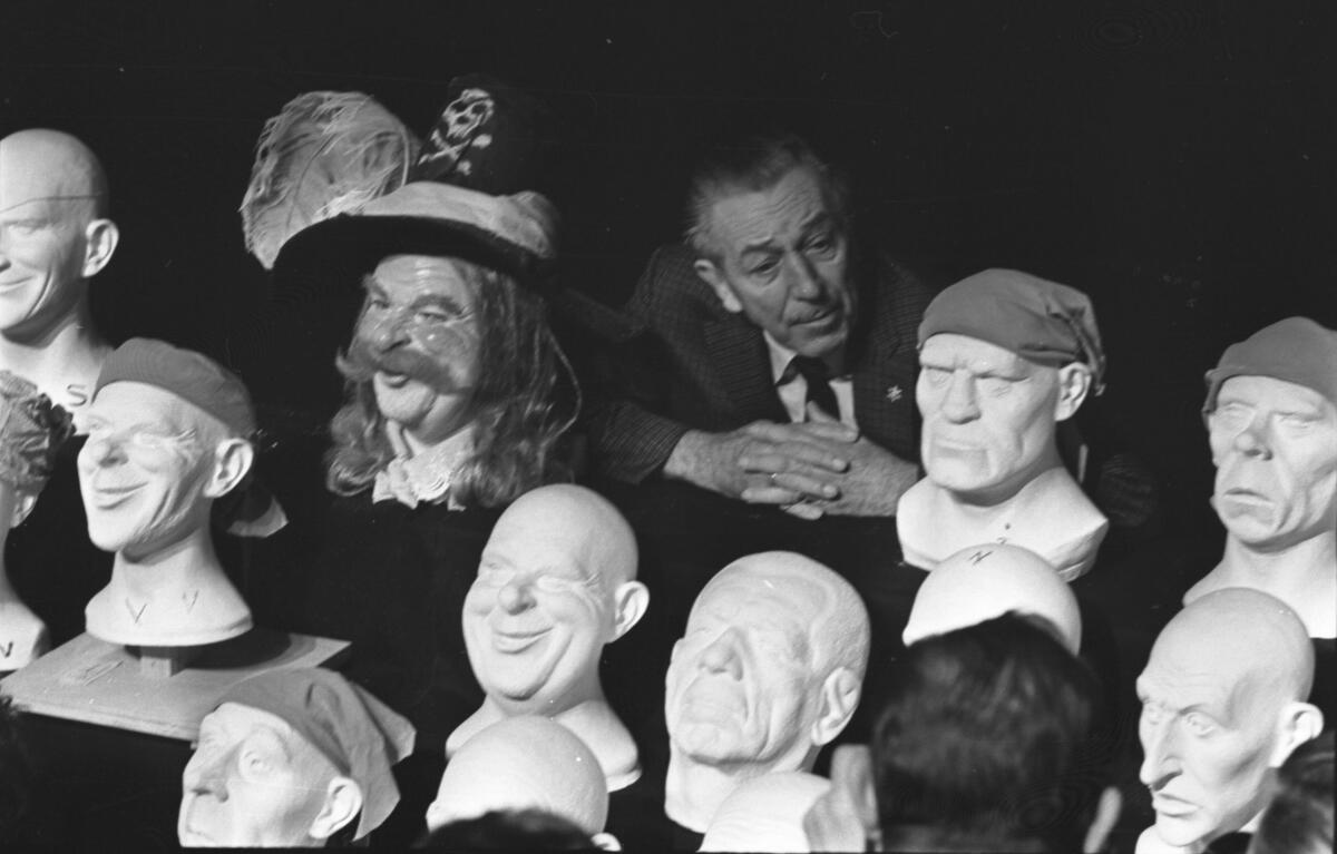 Walt Disney inspects "Pirates of the Caribbean" heads.
