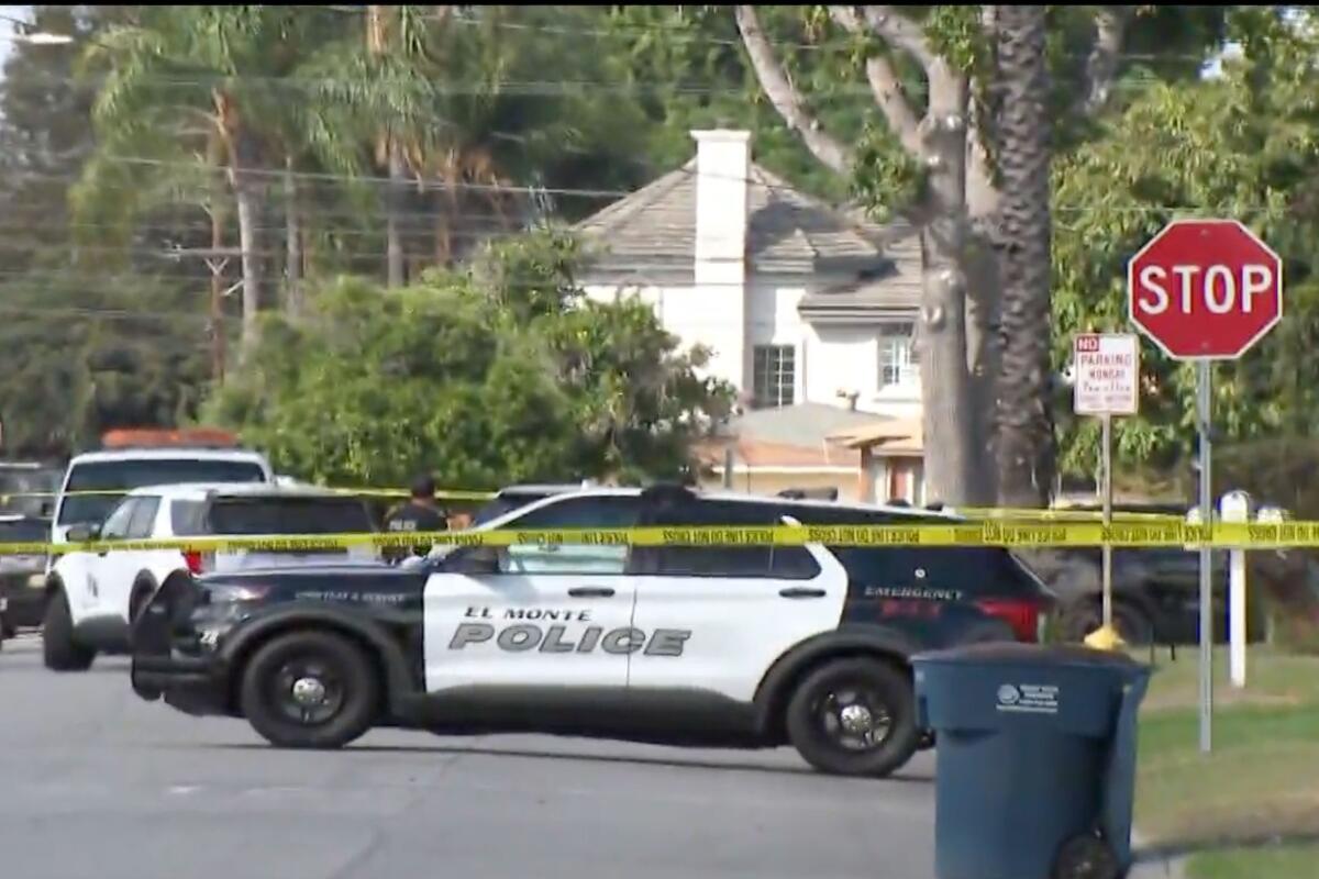 A police cruiser next to crime scene tape on a street.