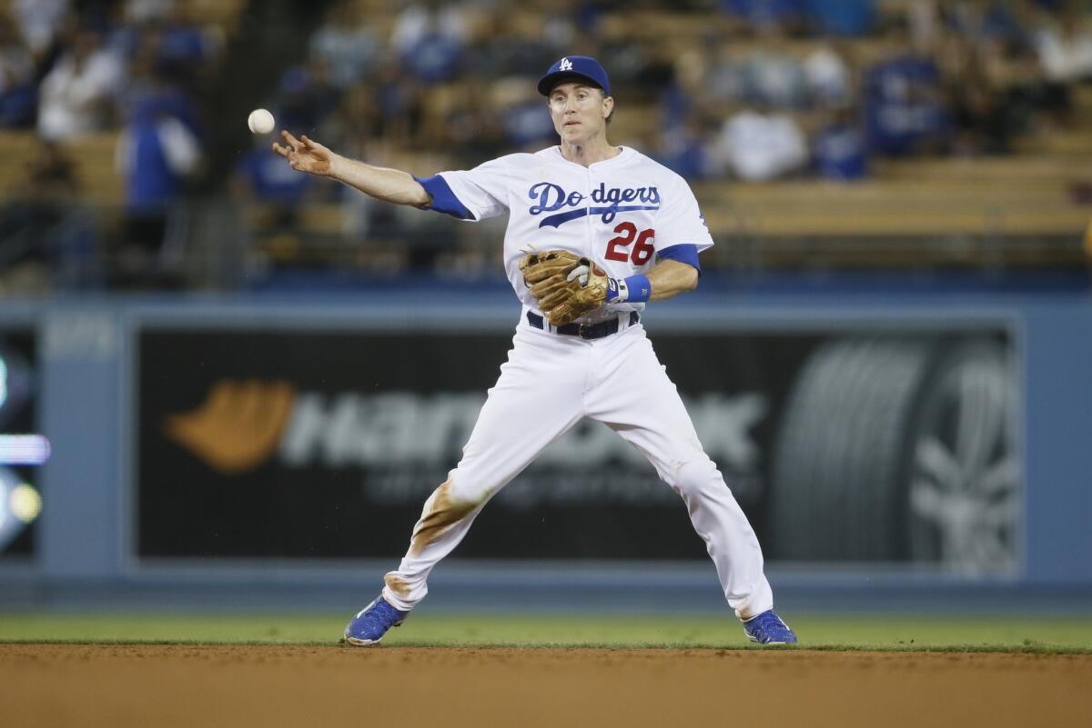 Dodgers infielder Chase Utley throws the ball to first base during a game against the Rockies on Sept. 15.
