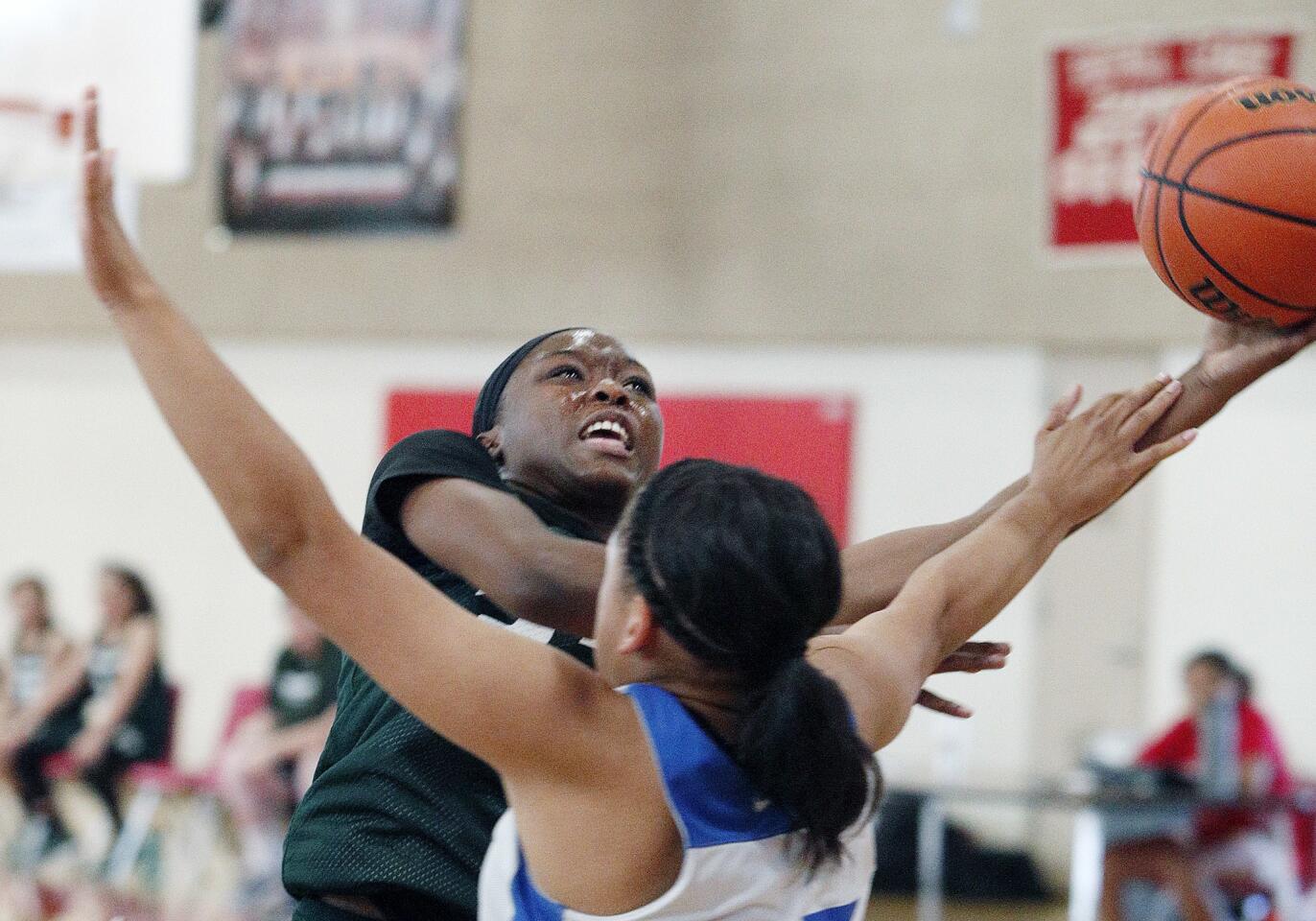 Providence's Jyah LoVett reaches to shoot against Burbank's Dakota Cortez in a Burroughs High School summer league girls' basketball game on Tuesday, July 10, 2018.