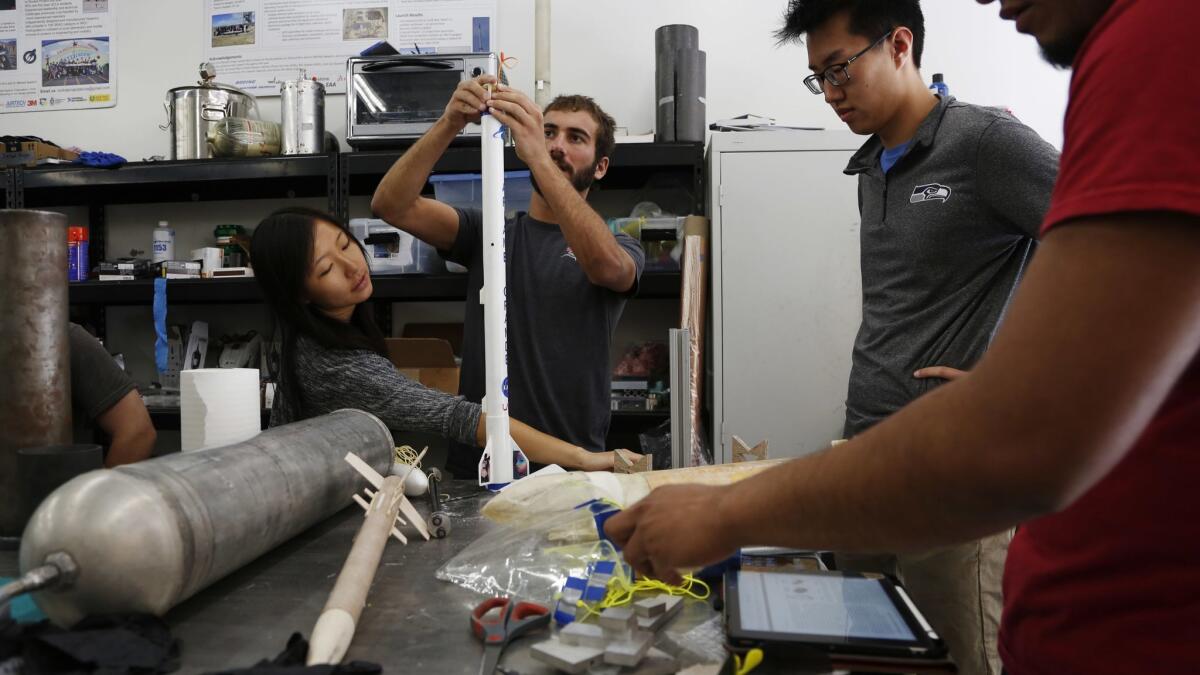 UCLA seniors Katherine Lee, left, Quincy Zlotnick, center, and David Lu, second from right, work on their hybrid motor rocket in their senior capstone class.
