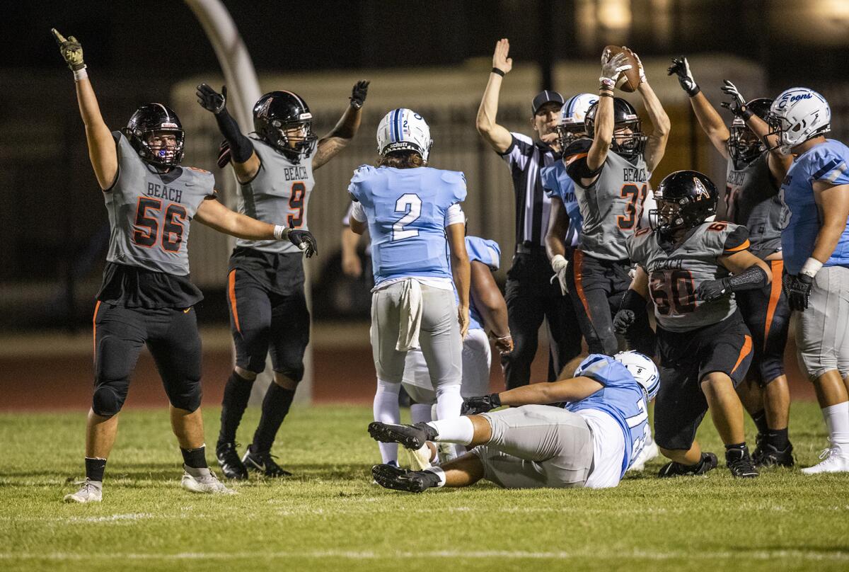Huntington Beach's Nicholas Loboda recovers a fumble in the red zone against Mayfair in a season opener on Friday.