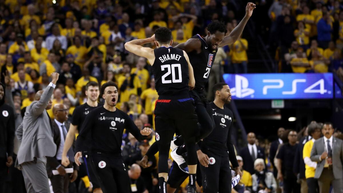 Clippers' Landry Shamet (20) is congratulated by Patrick Beverley (21) after he made a basket to put the Clippers ahead of the Golden State Warriors in the final minute during Game 2 of the first round of the 2019 NBA playoffs on Monday in Oakland.