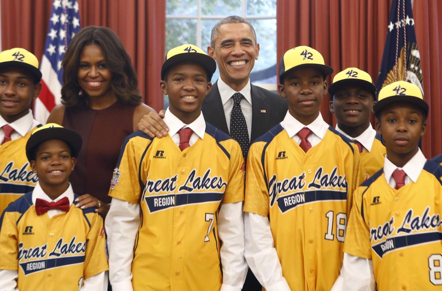 President Barack Obama and first lady Michelle Obama pose with the 2014 U.S. champion Jackie Robinson West All-Stars Little League baseball team Nov. 6, 2014, in the Oval Office.