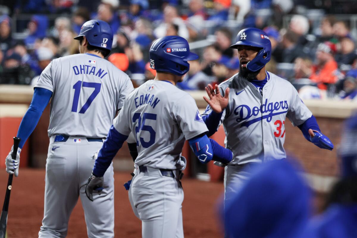 Teoscar Hernández, right, celebrates with Tommy Edman after scoring during the second inning of Game 3 of the NLCS.