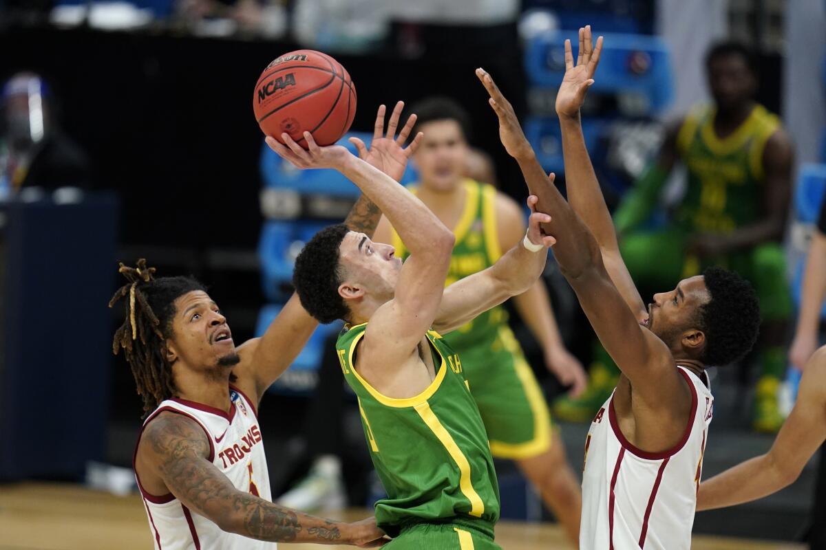 Oregon guard Chris Duarte attempts a floating shot over USC forward Evan Mobley.