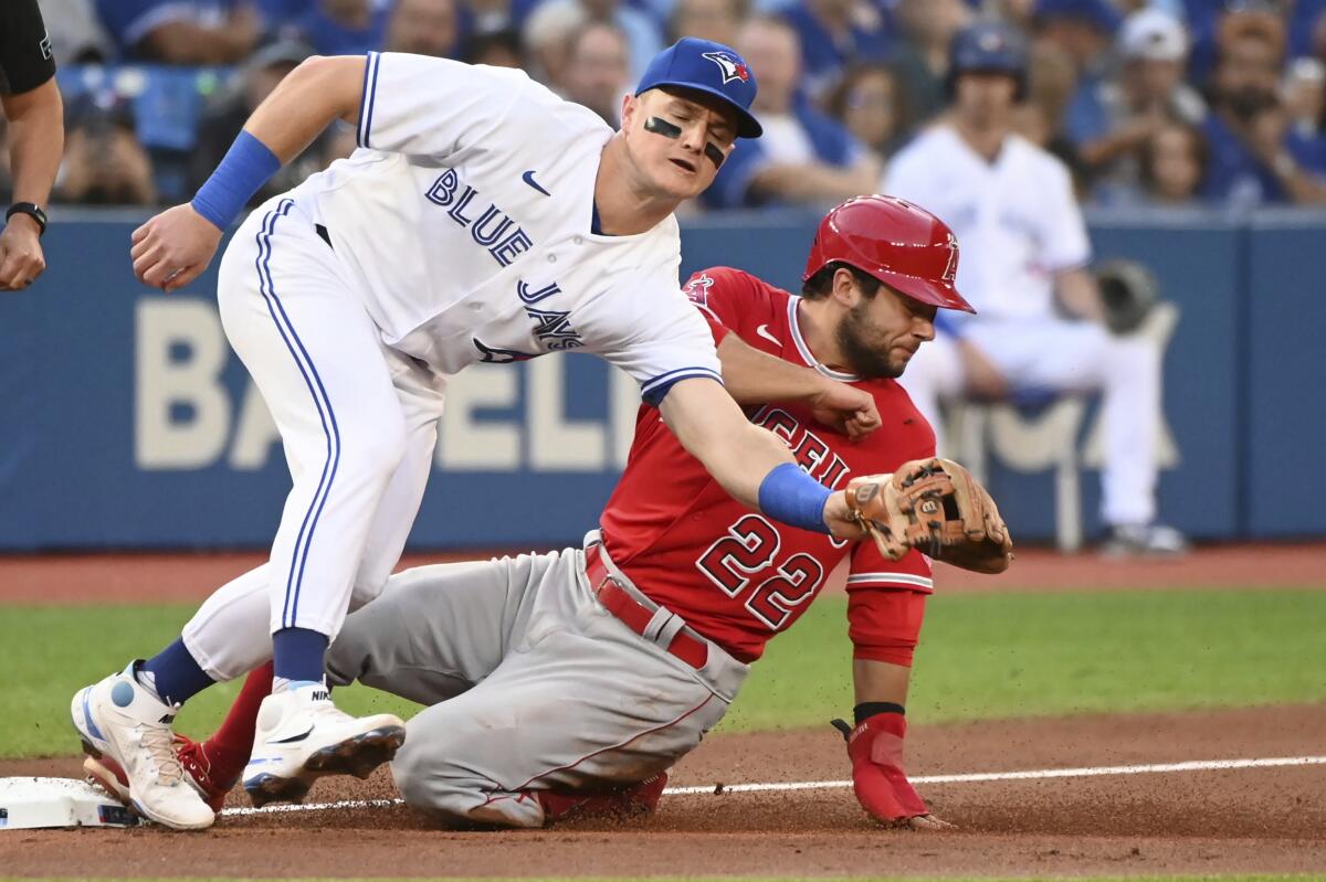 The Angels' David Fletcher slides into third ahead of a tag by the Blue Jays' Matt Chapman in the first inning.