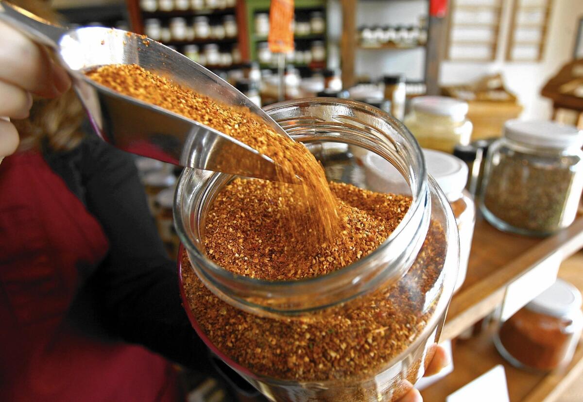 A mix of fresh spices called Barrier Reef is poured into a jar at Savory Spice Shop in Corona del Mar. The store is scheduled to close June 19.