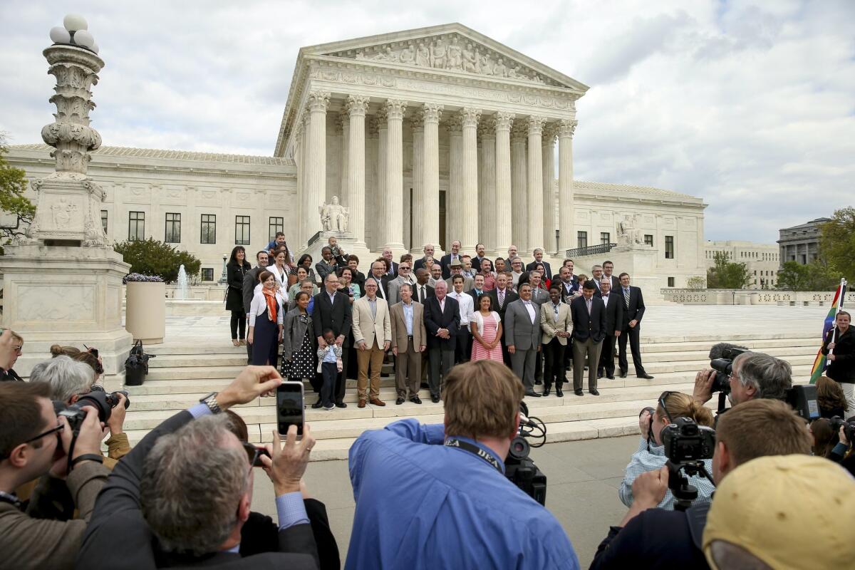 Plaintiffs from Tennessee, Michigan, and Ohio pose for photographs with the lawyers representing them in front of the Supreme Court on April 27.