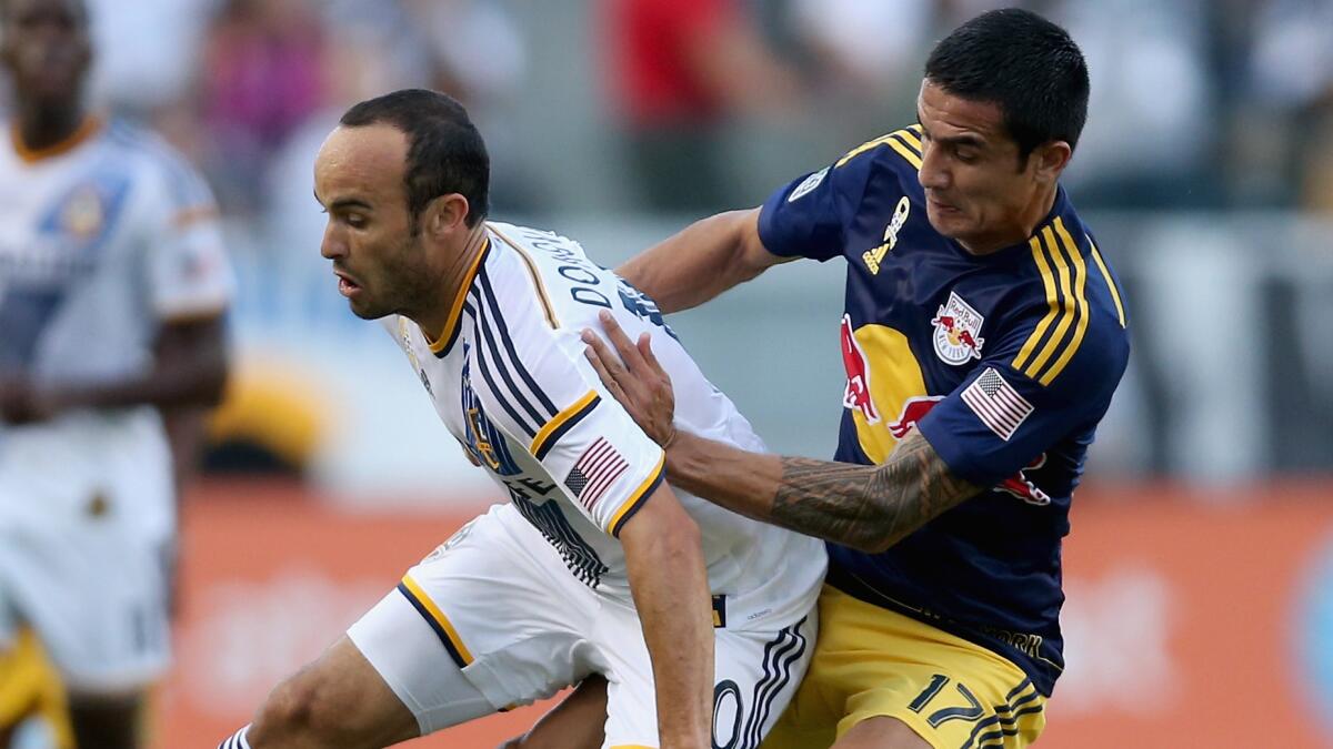 Galaxy forward Landon Donovan, left, battles New York's Tim Cahill for the ball during a match on Sept. 28.