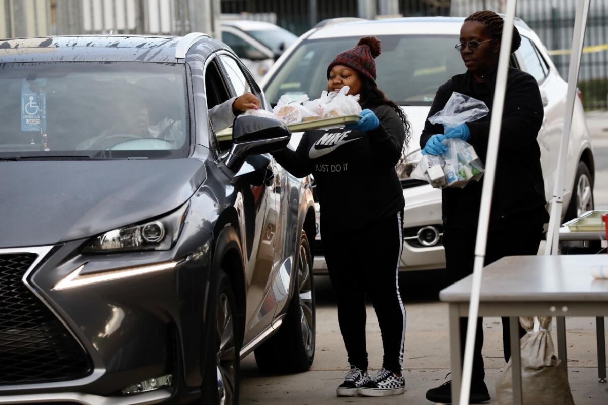 LAUSD volunteer Courtney Johnson delivers food to drivers at Dorsey High School.