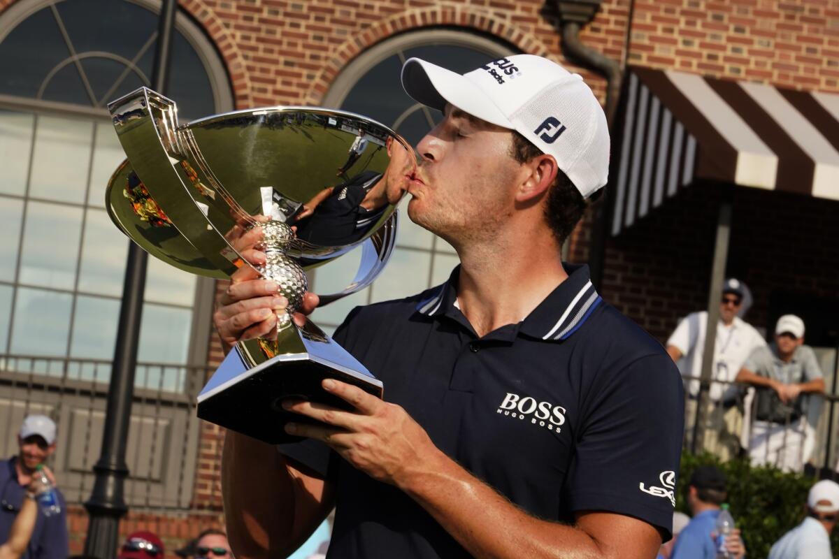 Patrick Cantlay kisses the trophy after winning the Tour Championship golf tournament and the FedEx Cup at East Lake Golf Club, Sunday, Sept. 5, 2021, in Atlanta. (AP Photo/Brynn Anderson)