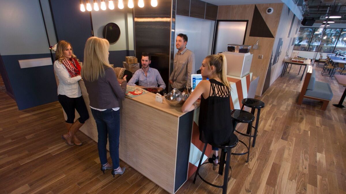 WeWork staff and members gather around the reception desk on the third floor.