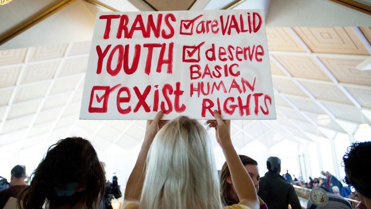 A protester holds a sign as the North Carolina Legislature meets to debate enacting a controversial bathroom ban.