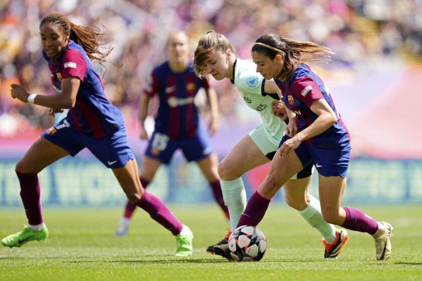Barcelona's Aitana Bonmati, right, vies for the ball with Chelsea's Niamh Charles during the women's Champions League semifinals, first leg, soccer match between FC Barcelona and Chelsea FC at the Olympic Stadium, in Barcelona, Spain, Saturday, April 20, 2024. (AP Photo/Jose Breton)