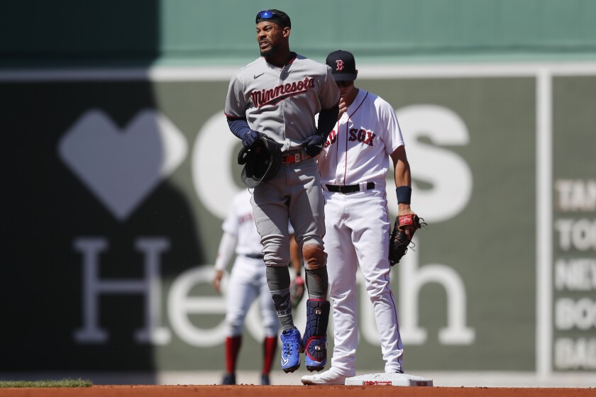 Minnesota Twins' Byron Buxton, front, reacts after being injured on his double during the first inning of a baseball game against the Boston Red Sox, Friday, April 15, 2022, in Boston. Buxton was replaced in the game by Nick Gordon.(AP Photo/Michael Dwyer)