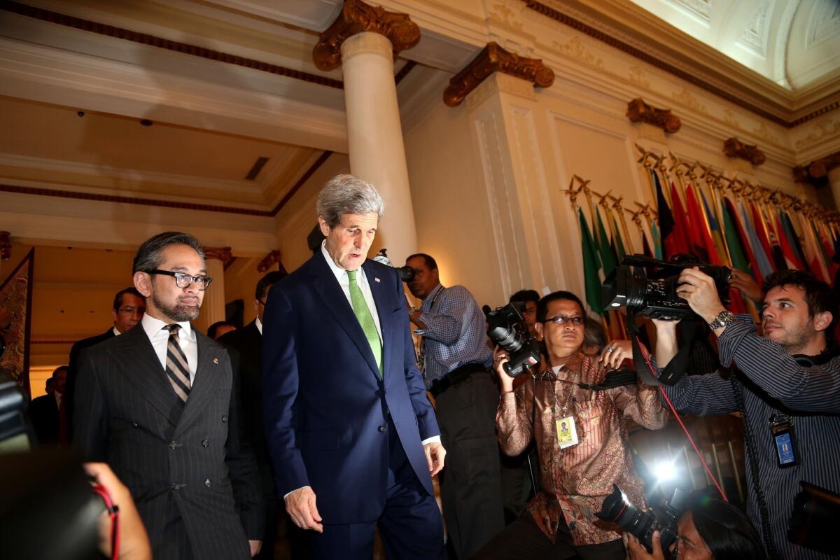 U.S. Secretary of State John Kerry, center, arrives for a news conference with Indonesian Foreign Minister Marty Natalegawa in Jakarta, Indonesia.