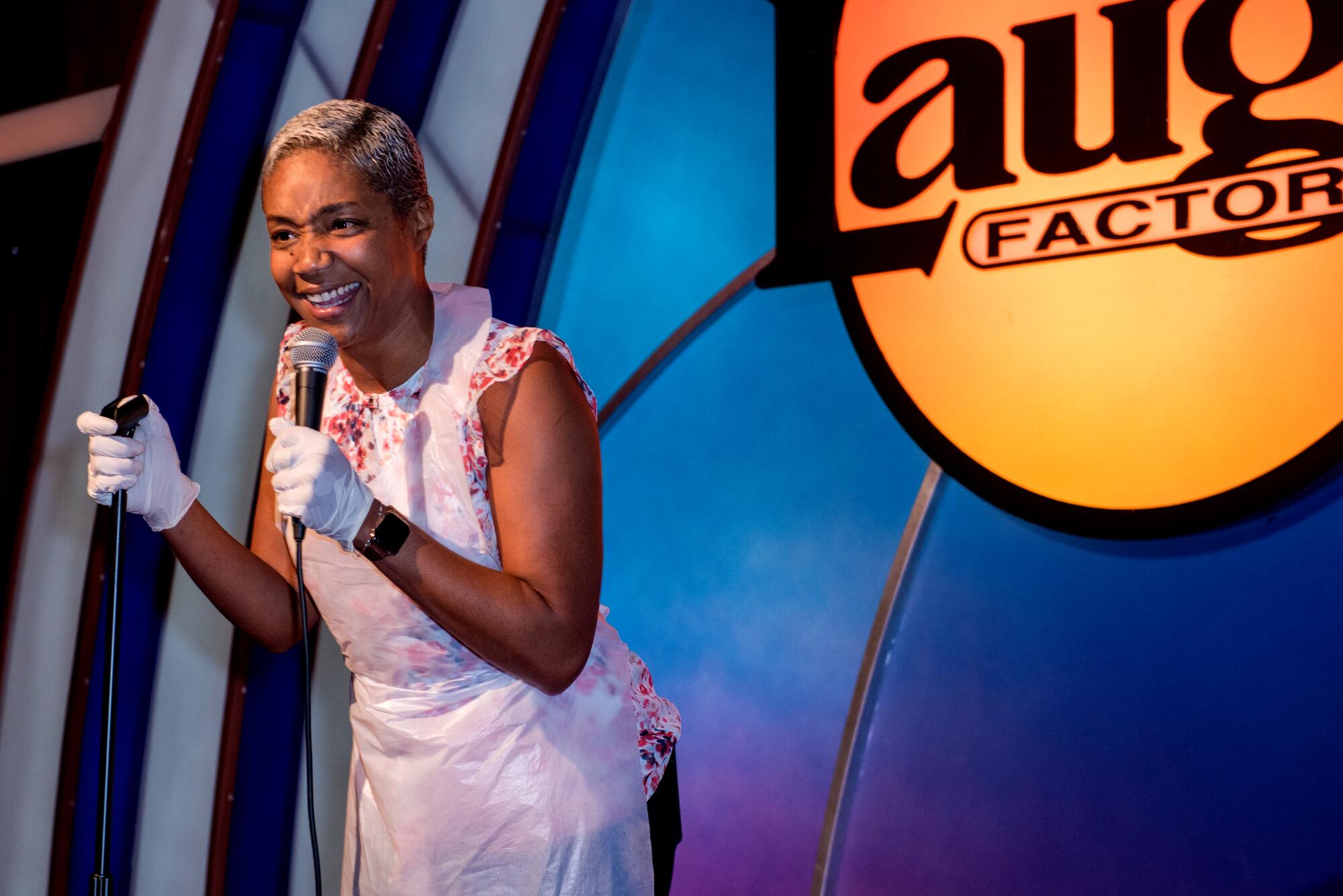 Tiffany Haddish wears latex gloves and a plastic apron onstage at the Laugh Factory on Nov. 23, 2023.