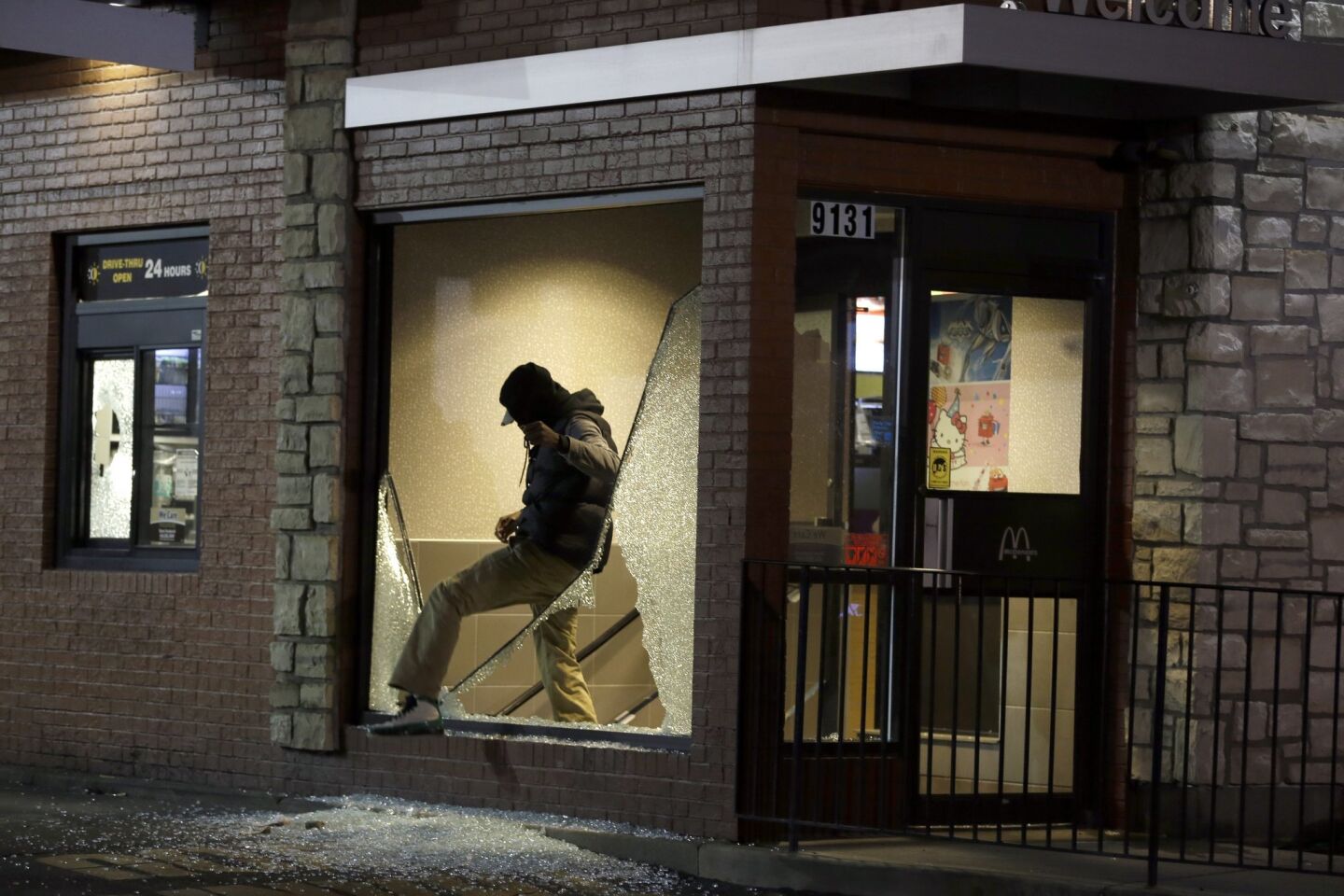 A man steps out of a vandalized McDonald's restaurant in Ferguson, Mo., after the grand jury decision was announced.