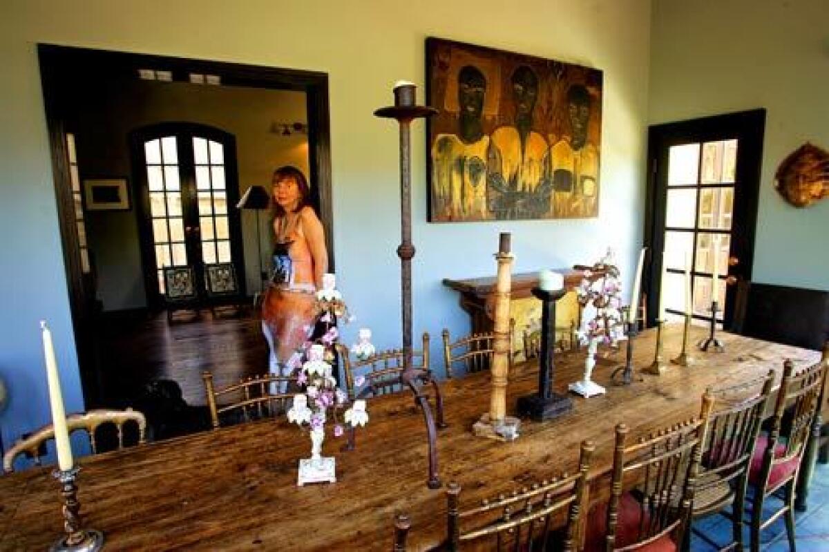 A 2003 Home cover story followed Laurie Frank as she prepared and hosted one of her renowned dinner parties at her Whitley Heights house. Sixteen months later, an electrical fire in the kitchen led to extensive water and smoke damage that required the structure to be taken down to the studs. Here, she stands in her rebuilt dining room next to her long Guatemalan altar table, salvaged from the fire and refinished, and antique ballroom chairs.