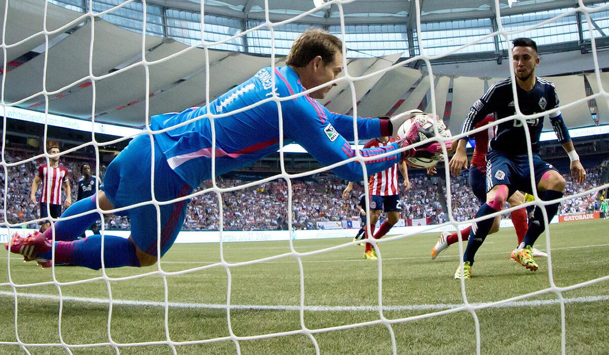Chivas USA goalkeeper Dan Kennedy dives to stop a shot against the Whitecaps during an MLS game last month in Vancouver.