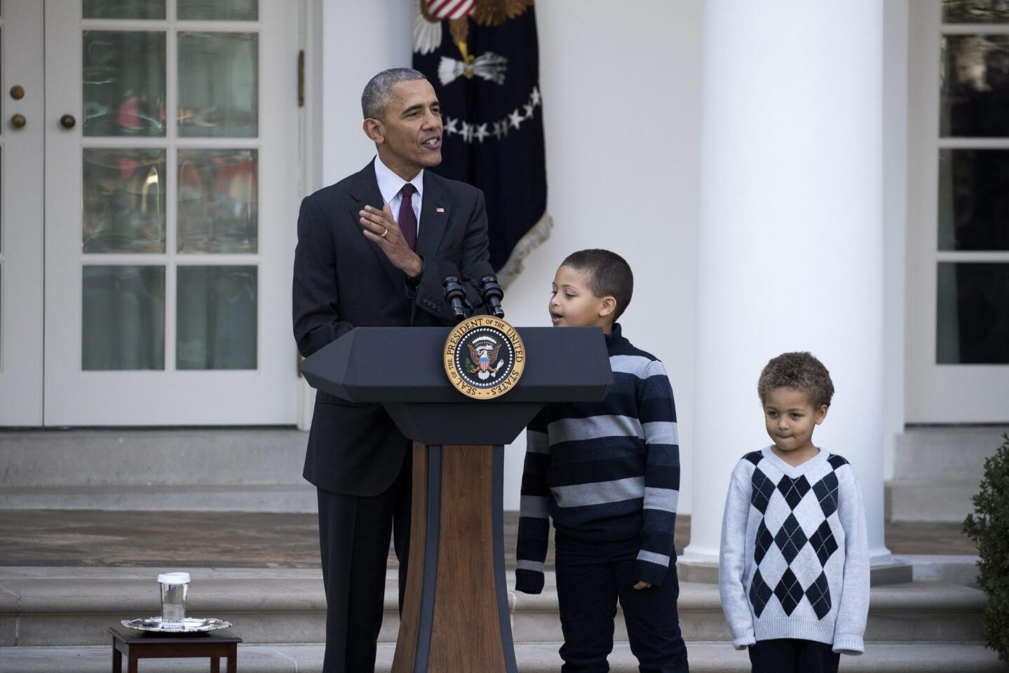 El presidente de Estados Unidos, Barack Obama (i), acompañado de sus sobrinos Austin (c) y Aaron Rbinson (d), ofrece un discurso tras perdonar a 'Tater', el pavo nacional del Día de Acción de Gracias, en el Jardín de las Rosas de la Casa Blanca en Washington.