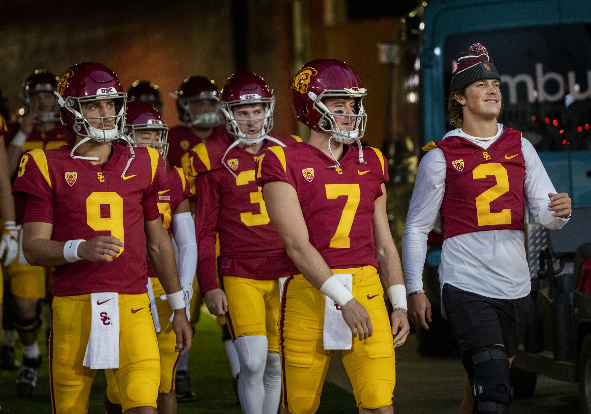 Injured USC quarterback Jaxson Dart, far right, walks through the tunnel with fellow Trojans QBs Kedon Slovis and Miller Moss