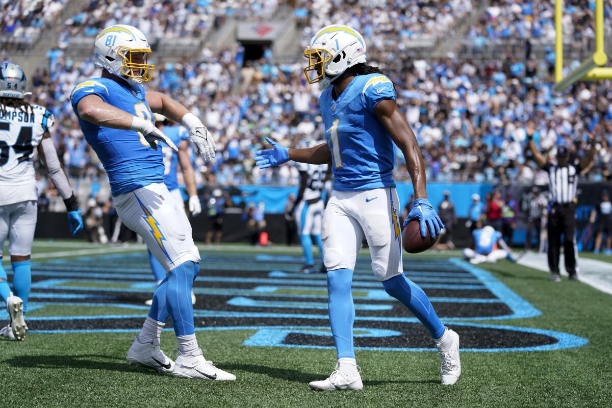 The Chargers' Quentin Johnston and  Will Dissly celebrate a touchdown catch.