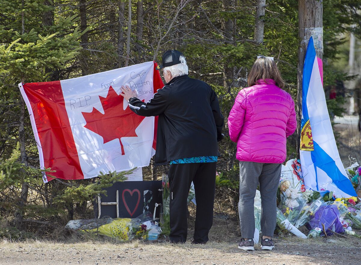 A couple visits a makeshift memorial for victims of a shooting rampage.