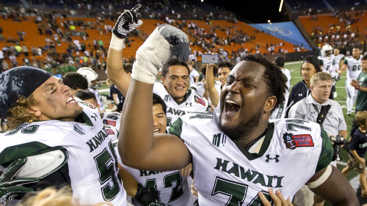 Hawaii offensive lineman RJ Hollis (74) celebrates with teammates after their victory over Middle Tennessee in the Hawaii Bowl on Saturday night.