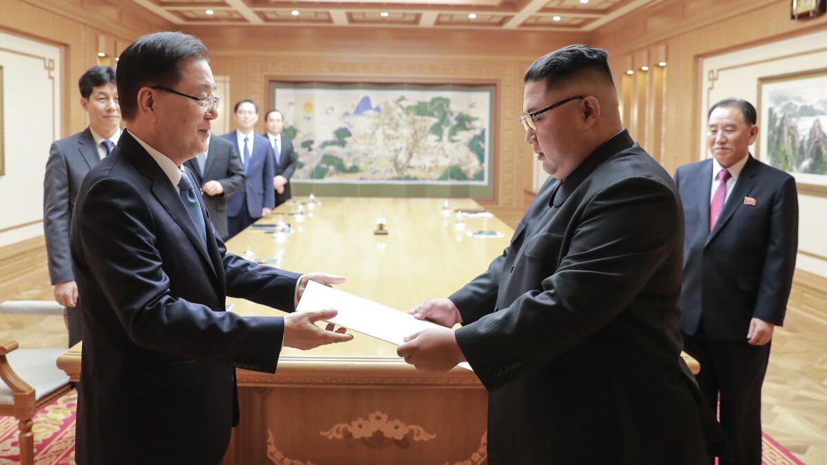 North Korean leader Kim Jong Un, right, receives a letter from South Korean President Moon Jae-in, delivered by Moon's national security advisor Chung Eui-yong, left, on Sept. 5 in Pyongyang.
