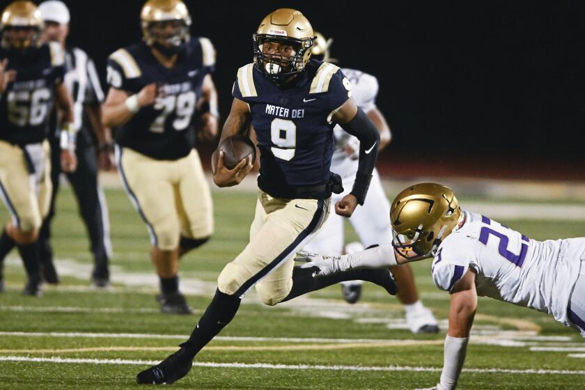 Mater Dei Catholic quarterback Kartell Purvis (9) gets past the defense of St. Augustine's Viliamu Trollinger (23) during the first half of a high school football game at Mater Dei Catholic September, 22, 2023 in San Diego. (Photo by Denis Poroy)